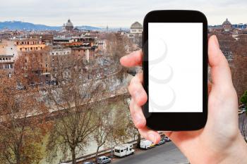 travel concept - hand holds smartphone with cut out screen and autumn Rome skyline on background