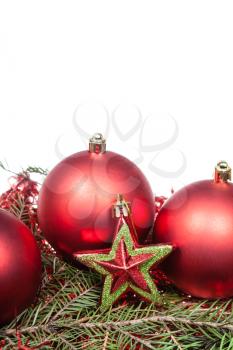 red star and red Christmas baubles on green spruce branch isolated on white background
