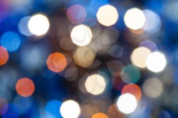 abstract blurred background - blue shimmering Christmas lights bokeh of electric garlands on Xmas tree