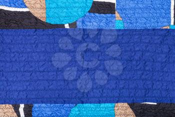 textile background from stitched crumpled blue silk fabric and patchwork