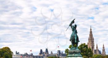 travel to Vienna city - statue of Archduke Charles on Heldenplatz square and towers of Rathaus in Vienna, Austria