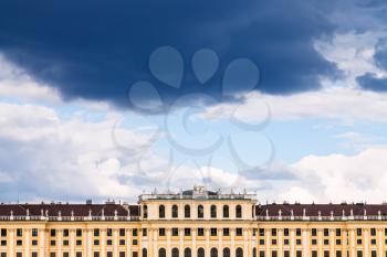 travel to Vienna city - dark storm cloud in blue sky over Schloss Schonbrunn palace, Vienna, Austria