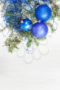Christmas greeting card - border from blue Xmas decorations and tree branch on blank paper background