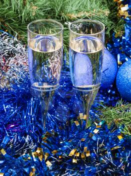 Christmas still life - Two glasses of sparkling wine with blue Xmas decorations on Christmas tree background