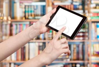 finger touches tablet pc with cut out screen in library