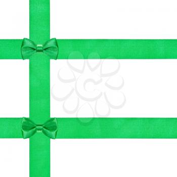 two little green bow knots on three satin ribbons isolated on white background