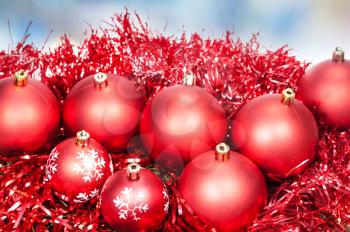 Xmas still life - red balls, tinsel with blue Christmas lights bokeh background