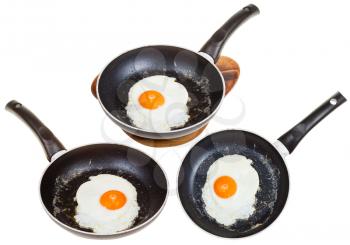 set of frypans with one fried egg isolated on white background