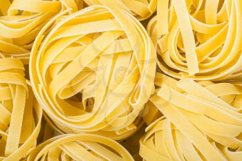 food background - nests of durum wheat semolina pasta fettuccine