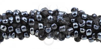 beadwork - many black glass beads sewn on necklace close up isolated on white background