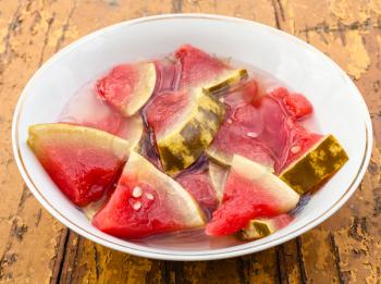 pickled watermelon on white plate on wooden table