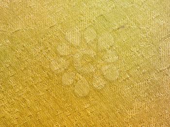 textile background - yellow colored silk fabric with Jacquard weave pattern of threads close up