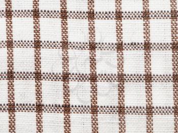 textile background - brown checkered cotton fabric with Calico weave pattern of threads close up