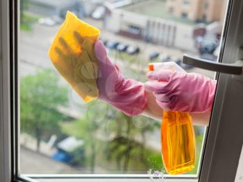 washing home window - cleaner cleans window glass with detergent in apartment house