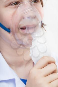 medical inhalation treatment - girl inhales with face mask of modern jet nebulizer