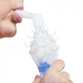 medical inhalation treatment - mouthpiece of modern jet nebulizer in lips of woman isolated on white background