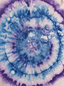 abstract ornament from blue and violet concentric circles on silk knotted batik