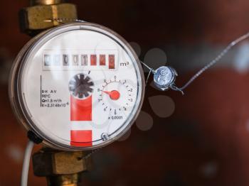 one new mechanical hot water meter on pipe close up