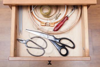 top view of accessories for embroidery in open drawer of nightstand