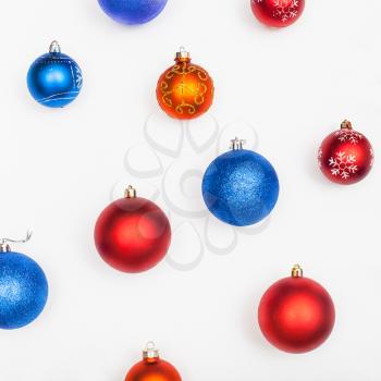 several blue, red, orange christmas balls on white background