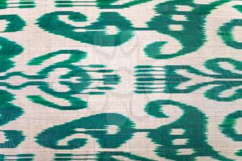 textile background - traditional central asian green pattern on silk fabric