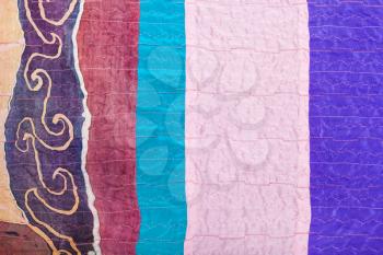 textile background - stitched pieces of clenched silk fabrics and painted batik