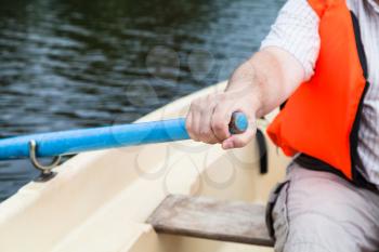 paddler in life jacket with oar on boat during water walk