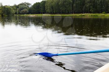 float on boat with oars in city pond. Big Garden (Academic) Pond, Moscow