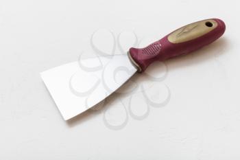 metal spatula with plastic handle on concrete floor