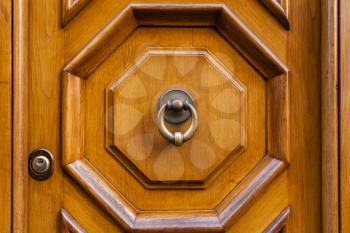 travel to Italy - external brass door knocker on brown wooden door in Rome city