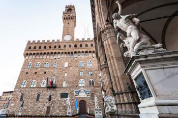 travel to Italy - view of statue (The Rape of the Sabine Women) in Loggia dei Lanzi and Town Hall (Palazzo Vecchio) in Florence city in morning