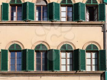 travel to Italy - facade of urban house with green window blinds in Florence city