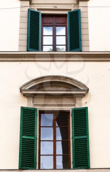 travel to Italy - two windows with green blinds in urban house in Florence city