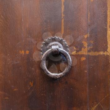 travel to Italy - ancient bronze round knocker on old brown door in Florence city
