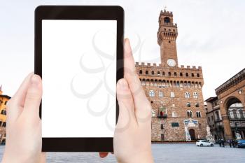 travel concept - tourist photographs Piazza signoria with Palazzo Vecchio in Florence city on tablet with cut out screen with blank place for advertising in Italy