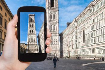 travel concept - tourist photographs campanile in Florence city on smartphone in Italy