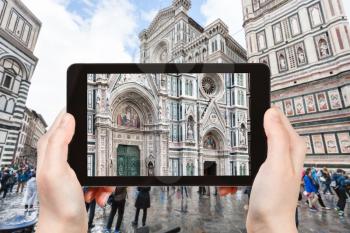 travel concept - tourist photographs facade of Duomo Santa Maria del Fiore in Florence city on tablet in Italy
