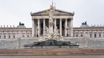 front view of Athena Pallas fountain and Austrian Parliament Building in Vienna city in spring