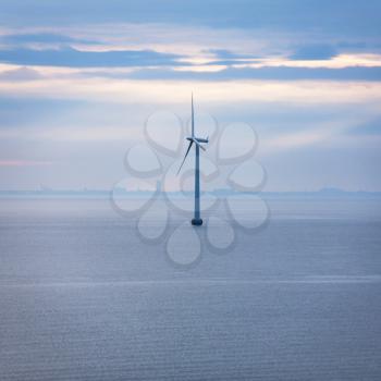 Travel to Denmark - one turbine of offshore wind farm Middelgrunden in Oresund near Copenhagen city in Baltic Sea in blue autumn morning