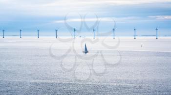 Travel to Denmark - boat and ship near offshore wind farm Middelgrunden in Oresund near Copenhagen city in Baltic Sea in blue autumn morning
