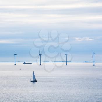 Travel to Denmark - view of boat, ship, airplane and offshore wind farm Middelgrunden in Oresund near Copenhagen city in Baltic Sea in blue autumn morning