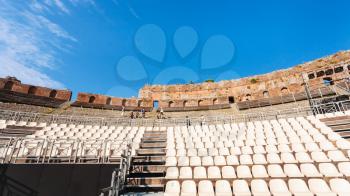 TAORMINA, ITALY - JULY 2, 2011: modern seats in ancient Teatro Greco (Greek Theatre) in Taormina city in Sicily. Arena was built in the third century BC.