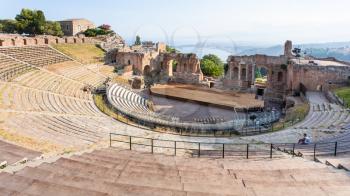 TAORMINA, ITALY - JULY 2, 2011: people in ancient Teatro Greco (Greek Theatre) in Taormina city in Sicily. Arena was built in the third century BC.