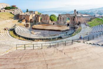 TAORMINA, ITALY - JULY 2, 2011: tourists in ancient Teatro Greco (Greek Theatre) in Taormina city in Sicily. Arena was built in the third century BC.