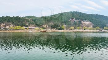 travel to China - panoramic view of East Hill with temples of Chinese Buddhist monument Longmen Grottoes (Dragon's Gate Grottoes, Longmen Caves) on Yi river in spring season.