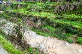travel to China - water stream near rice terraced fields in Dazhai village in area of Longsheng Rice Terraces (Dragon's Backbone terrace, Longji Rice Terraces) in spring season