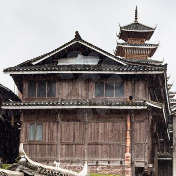 travel to China - wooden house and tower in Chengyang village in rain of Sanjiang Dong Autonomous County in spring