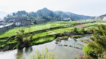 travel to China - view of gardens, rice field, tea plantation near river in Chengyang village of Sanjiang Dong Autonomous County in spring morning