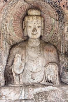 LUOYANG, CHINA - MARCH 20, 2017: Sakyamuni statue in Middle Binyang Cave in Longmen Grottoes (Longmen Caves). The complex was inscribed upon the UNESCO World Heritage List in 2000