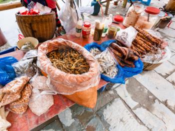 CHENGYANG, CHINA - MARCH 27, 2017: stall with local products on market in Chengyang village of Sanjiang Dong Autonomous County in spring. Chengyang includes eight villages of the Dong people